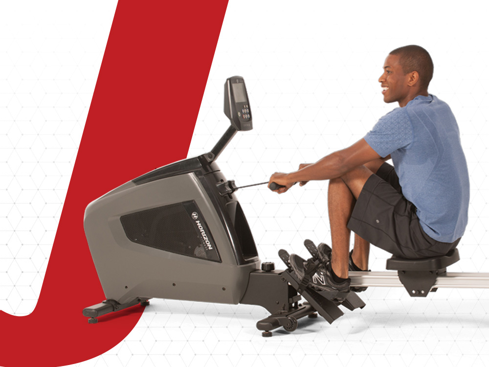 A man is indoor rowing on a rowing machine.