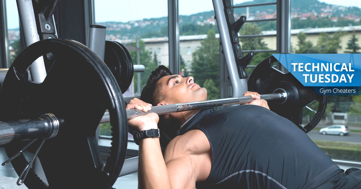 Muscular man bench pressing in a gym.