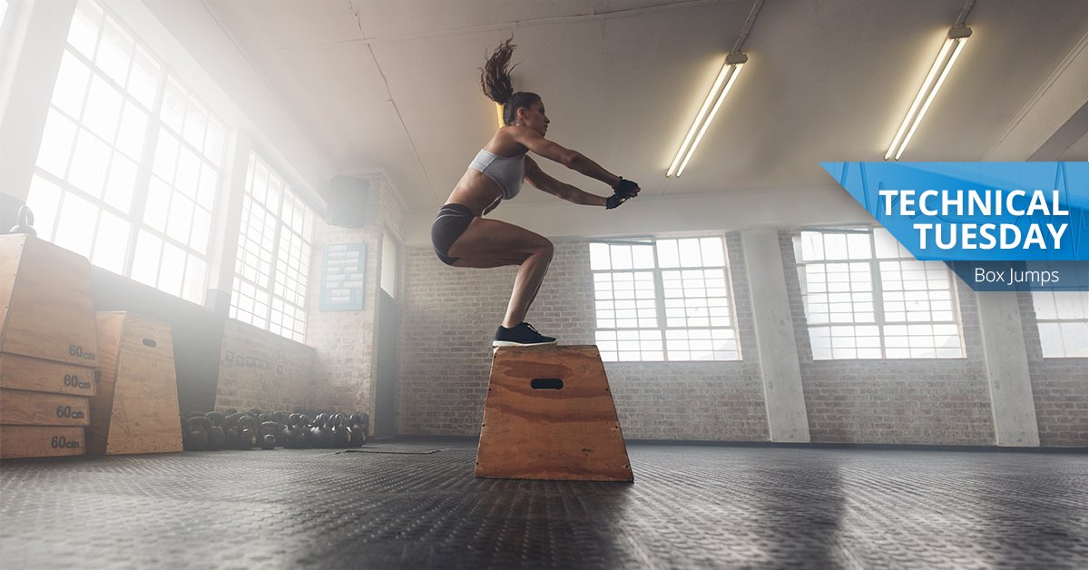 Woman doing box jumps on a plyo box in a gym